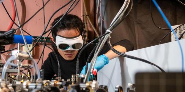 旗忠梁, a PhD candidate in JILA and the Department of Physics, demonstrates how the laser-based breathalyzer works, in the Ye lab at JILA.